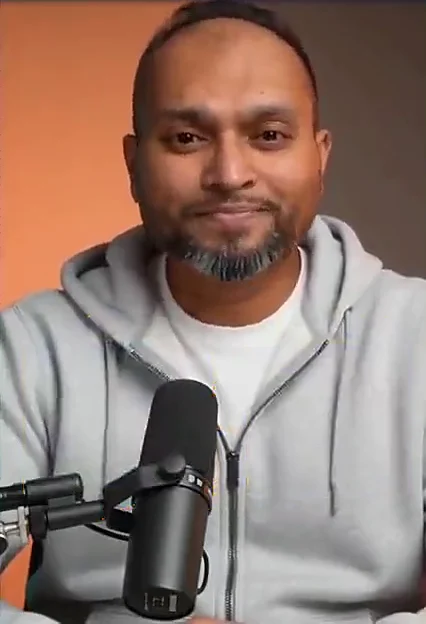 Mr Azad, smiling, in front of his microphone, ready to teach